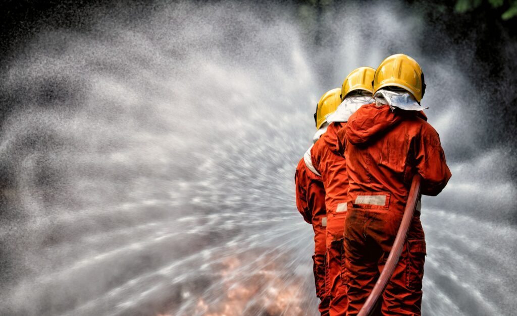 fire fighter team on training with gas and oil fire hold hose spray jet water spray to extinguish