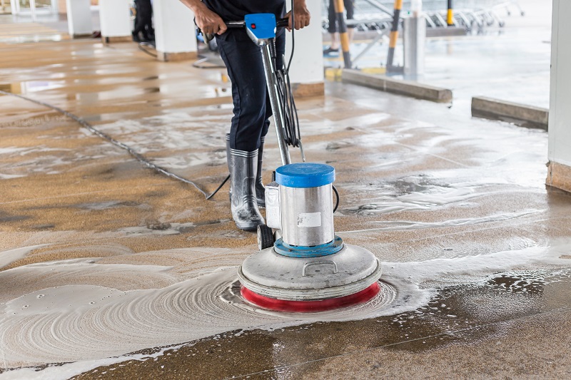 worker cleaning sand wash exterior walkway